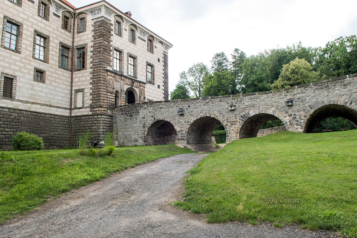 Фасад здания замка Нелагозевес с выступающим ризалитом и ведущий к нему мост, под которым располагался засыпанный за ненадобностью оборонительный ров.