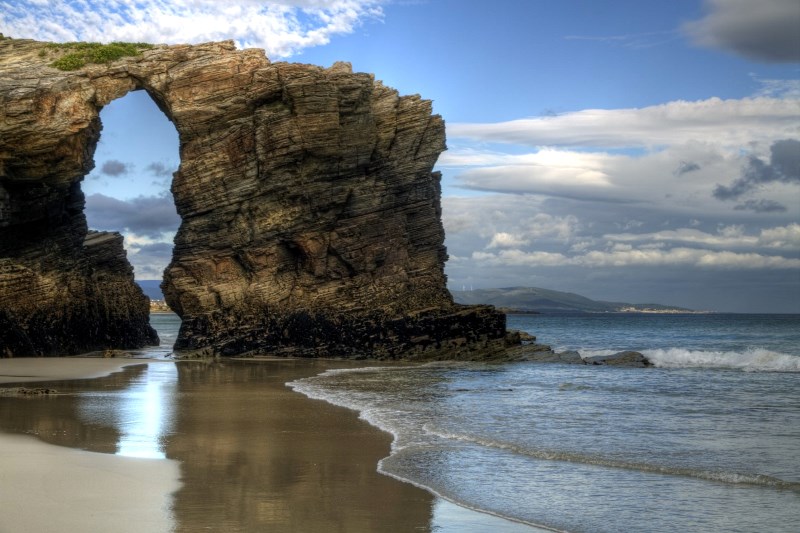 Своим названием пляж обязан скалам, возвышающимся на побережье