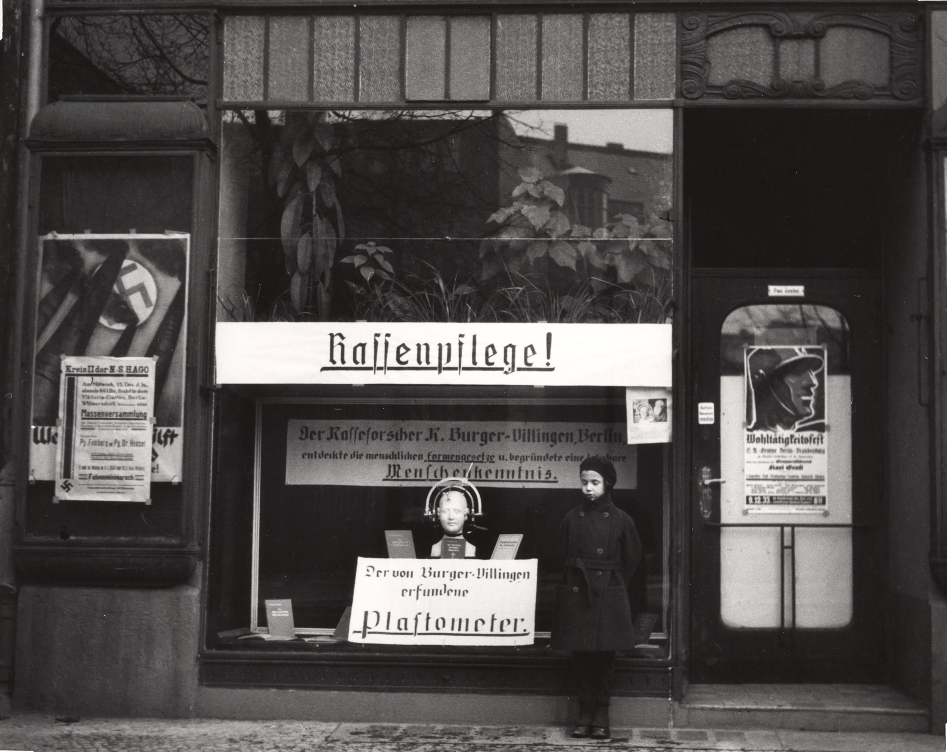 1933. Дочь Вишниака Мара позирует перед магазином, специализирующимся на инструментах, измеряющих разницу в размерах между арийскими и неарийскими черепами. Берлин