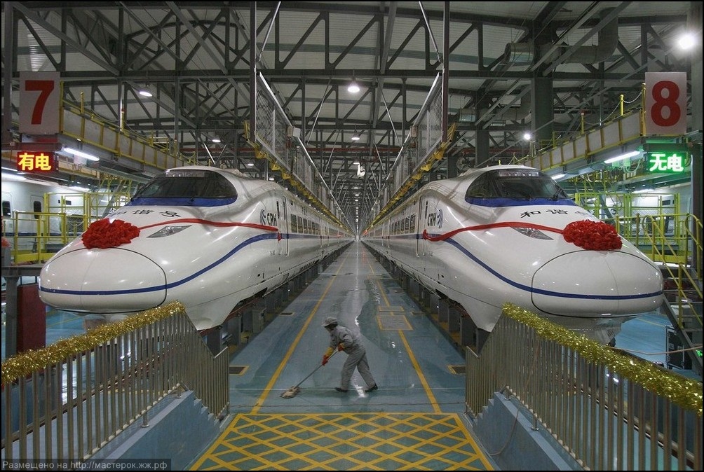 A labourer cleans the floor beside a China Railway High-speed train preparing for the operation ceremony from Wuhan to Guangzhou in Wuha n