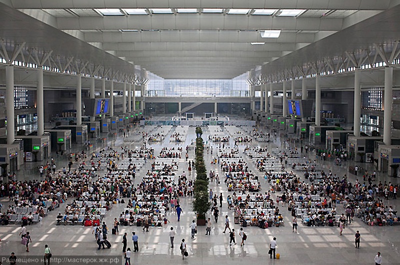 A labourer cleans the floor beside a China Railway High-speed train preparing for the operation ceremony from Wuhan to Guangzhou in Wuha n