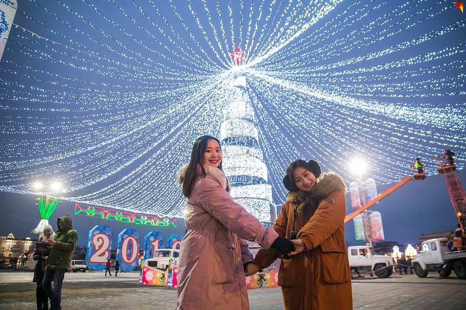 Иностранцы с удовольствием фотографируются у новогодней елки. Фото: Павел МАРТИНЧИК