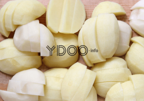 нарезанный картофель на деревянной разделочной доске